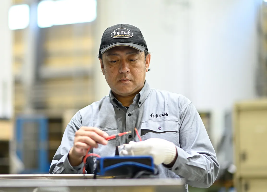 fujimakで働く製品検査職のYさんが機器を使用して点検する様子