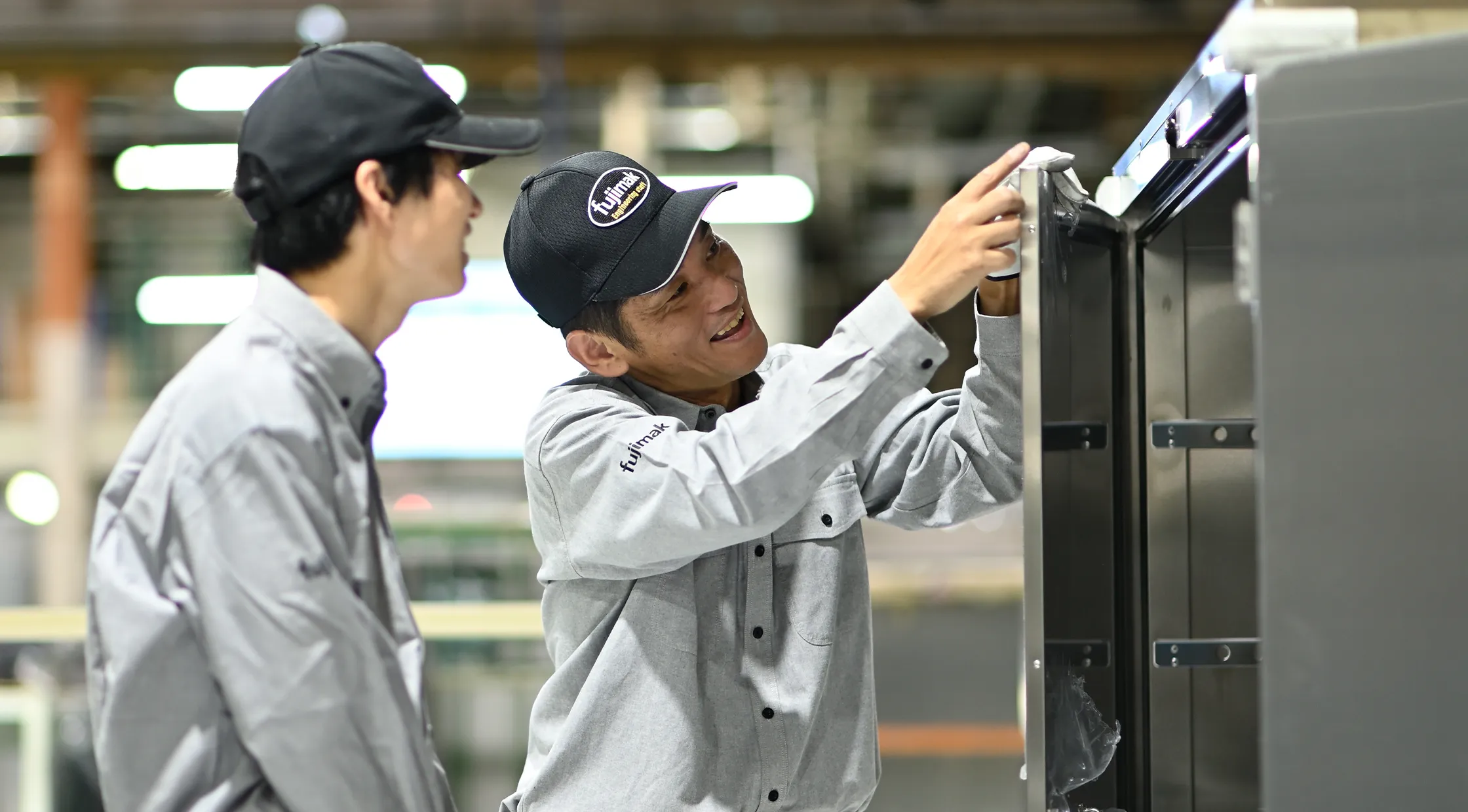 fujimakで働く製造職のTさんが同僚と機器の点検を行う様子