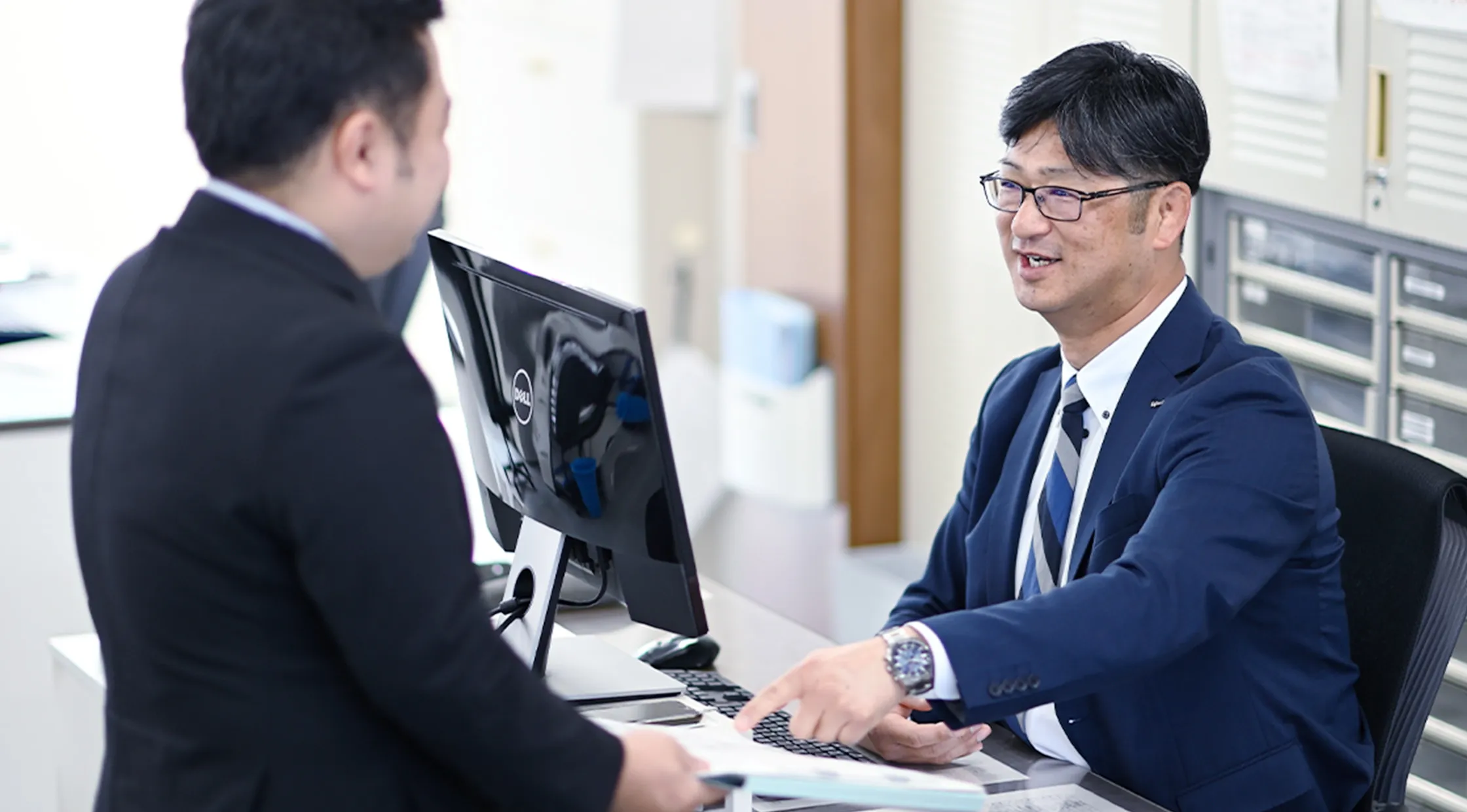 fujimakで働く営業職のYさん部下と話をする様子