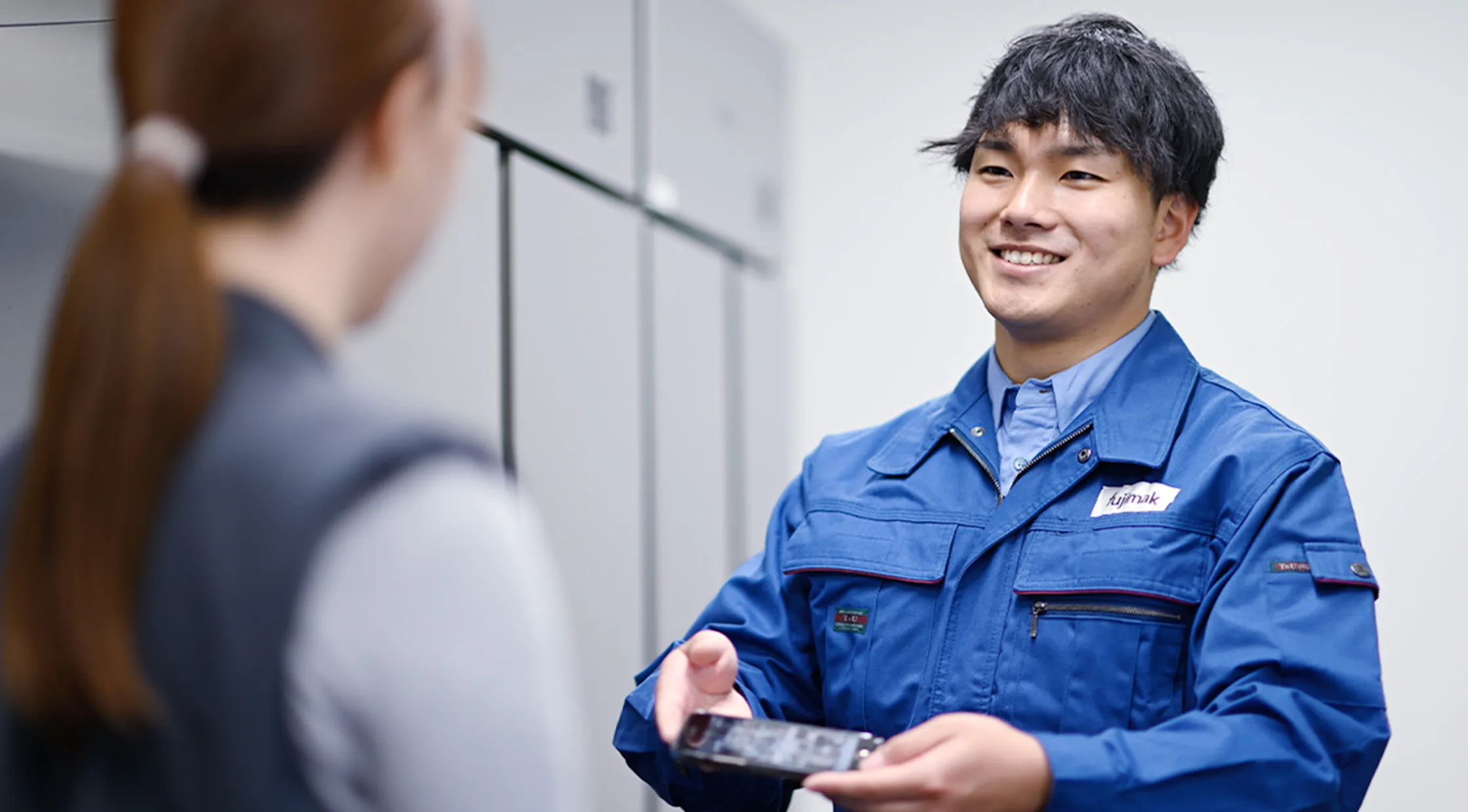 fujimakで働くサービスエンジニア職Oさんが部品の説明をする様子